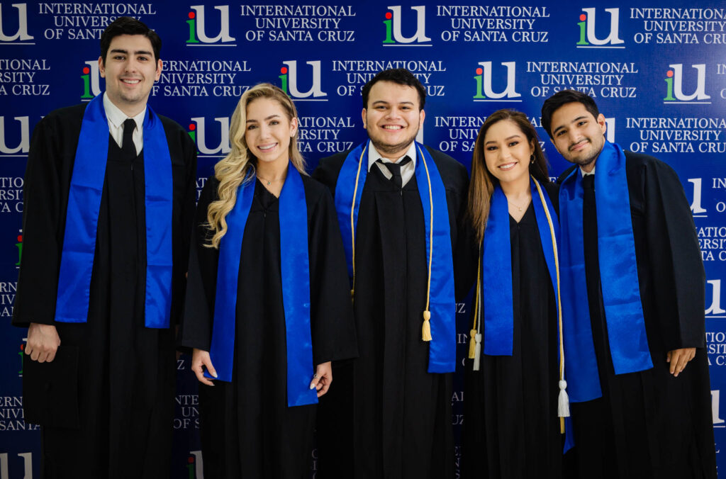 Graduados de International University of Santa Cruz (iU) con toga negra y estola azul