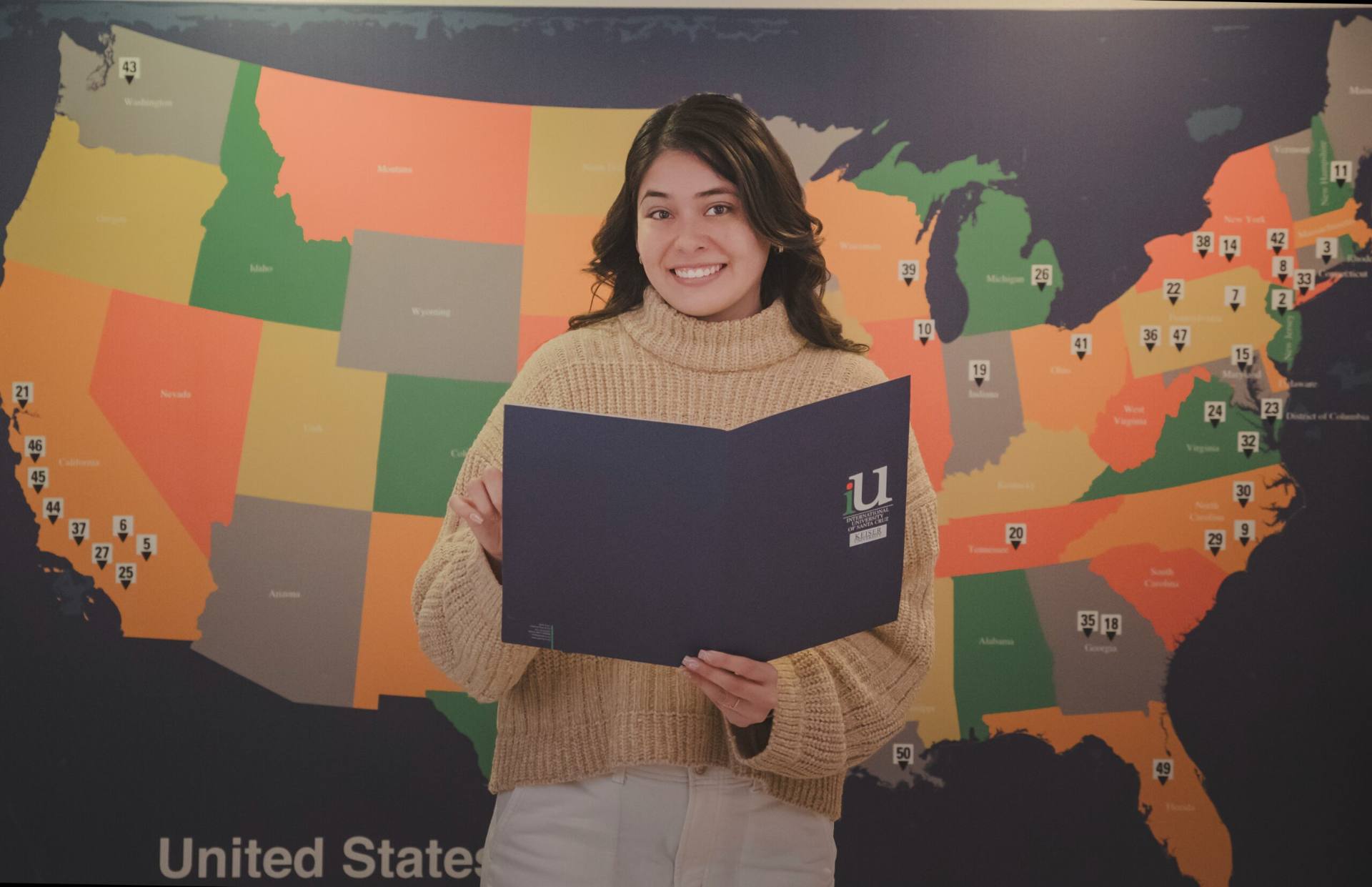 Alumna de International University of Santa Cruz frente a un mapa de Estados Unidos