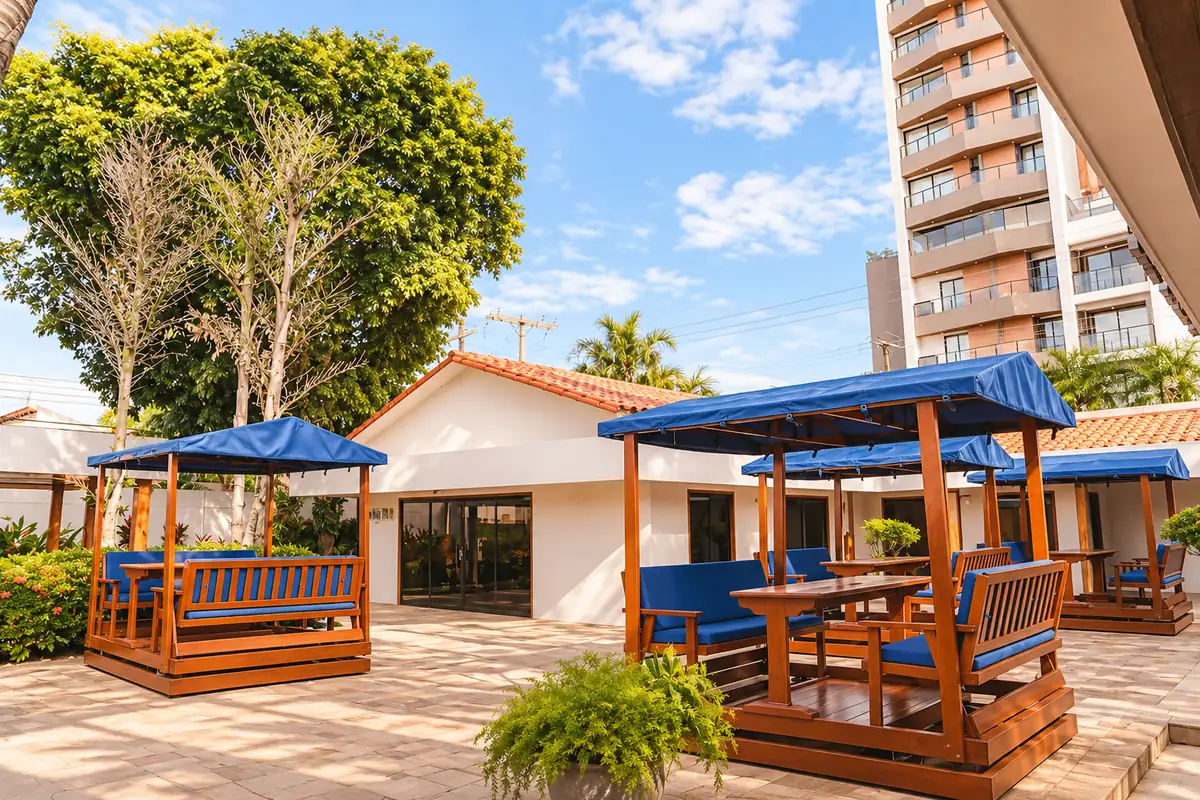 Área al aire libre del campus de iU, con mesas de madera y toldos azules